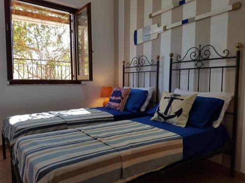 a bedroom with two beds with blue and white pillows at La dimora del capitano in San Vito lo Capo