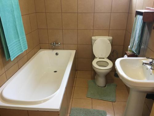 a bathroom with a tub and a toilet and a sink at Go Wild Resort in Xai-Xai