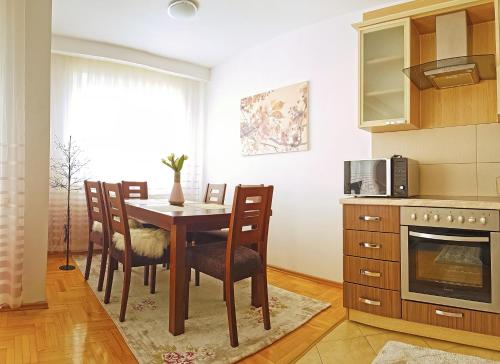 a kitchen with a table and chairs and a microwave at Apartment 31 in Pristina