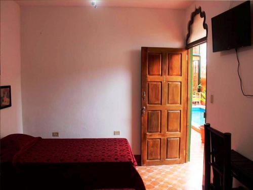 1 dormitorio con 1 cama y puerta de madera en Boutique Hotel Maharaja en Granada