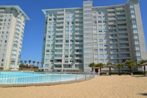two tall buildings on the beach next to a pool at Laguna vista 903 in Algarrobo