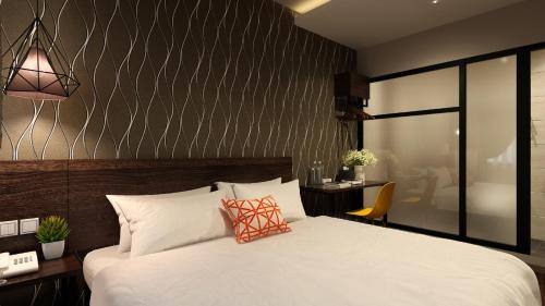 a bedroom with a large white bed and a desk at The Square Hotel in Skudai