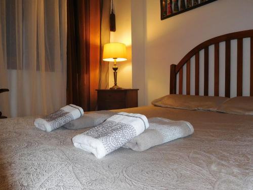 a bed with two pillows on top of it at Las Dunas Apartment in Albir