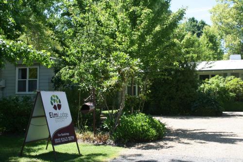 a sign in front of a house with a tree at Elm Lodge Bright in Bright