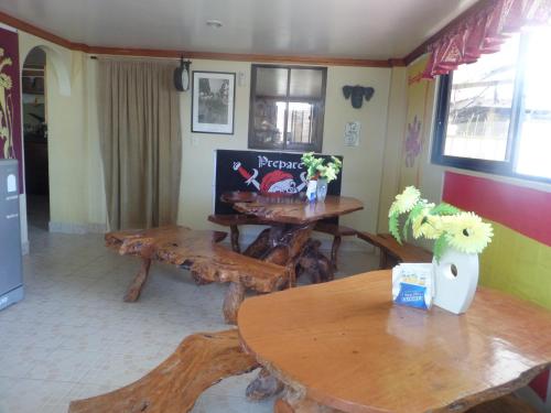a living room with wooden tables and a tv at Sailfishbay Surf And Big Game Fishing Lodge in San Isidro