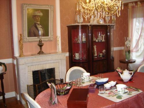 a dining room with a table and a fireplace at Chambres d'Hôtes Ty Mezad in Séné