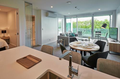 a kitchen and living room with a table and chairs at Swiss-Belsuites Victoria Park Auckland in Auckland
