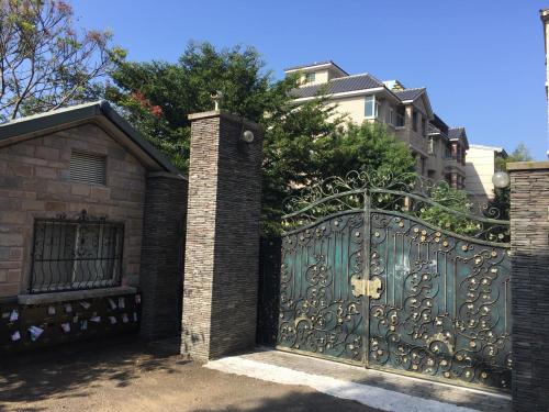 a gate to a house with a brick building at 响銅鑼民宿 in Tongluo