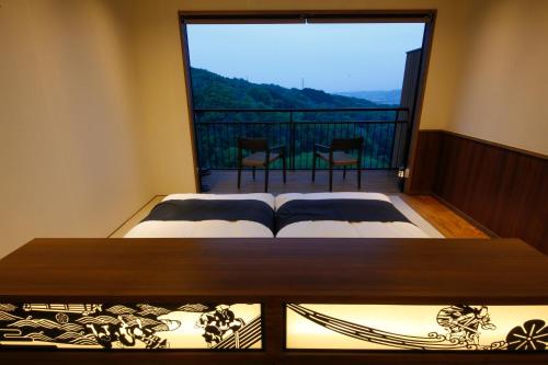 a bedroom with a bed and a large window at Kakimotoya in Sango