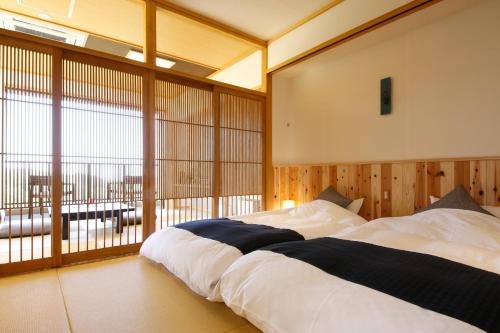 
a hotel room with a bed and a window at Kakimotoya in Sango
