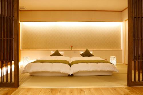 a bedroom with a large white bed in a room at Kakimotoya in Sango