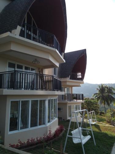 a house with a white swing in front of it at The Duyan House at Sinagtala Resort in Orani
