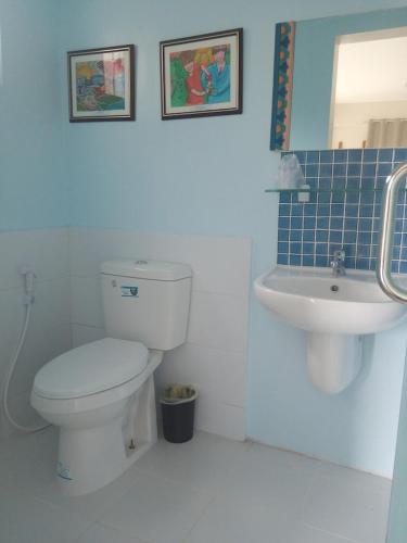 a bathroom with a toilet and a sink at The Duyan House at Sinagtala Resort in Orani