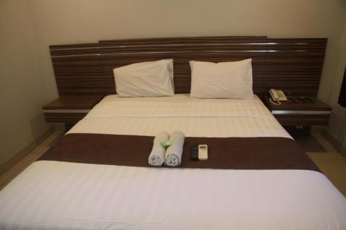 a bed with a pair of flip flops on it at Palapa Hotel in Mataram