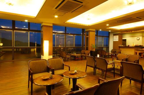 a restaurant with tables and chairs and windows at Kakimotoya in Sango
