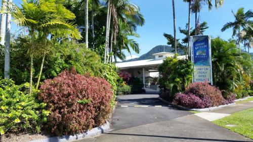 a large palm tree in front of a hotel at Cairns Gateway Resort in Cairns