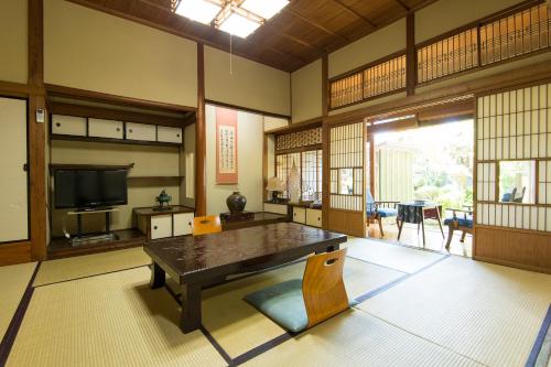 sala de estar con mesa de madera y TV en Ryokan Seifuso, en Ōmuta