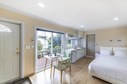 a bedroom with a bed and a kitchen with a window at Jubilee Chalet in Seogwipo