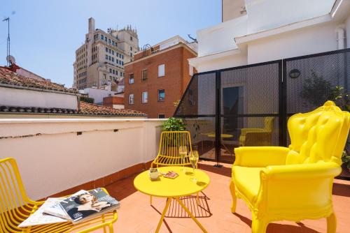 Un balcón con sillas amarillas y una mesa y sillas amarillas. en The Walt Madrid, en Madrid