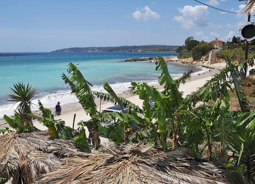 a beach with people walking on the sand and the ocean at Marinos Studios at Lourdata village in Lourdhata