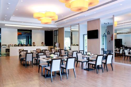 a restaurant with tables and chairs and a bar at Louis Tavern Hotel in Bangkok