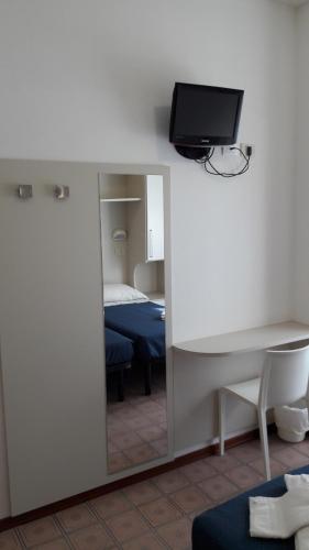 a room with a mirror and a bed and a desk at B&B - Meuble' - Hotel " CORDIALE " in Misano Adriatico