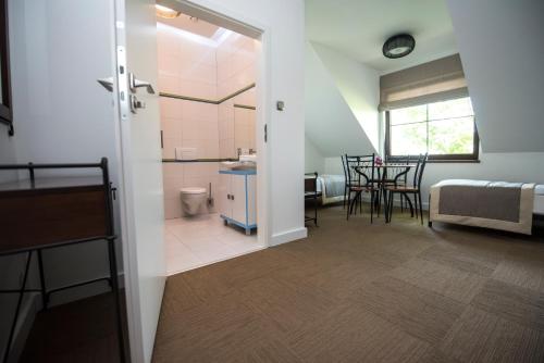 a room with a bathroom and a table with chairs at Apartamenty Giżycko in Giżycko