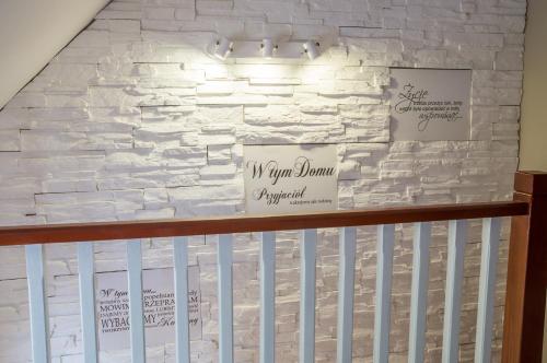 a white brick wall with signs on a crib at Gościniec Pod Lipą in Mikołajki