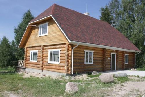 a log cabin with a red roof at Jaama Puhkemaja in Raigastvere