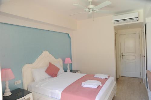 a bedroom with a bed and a ceiling fan at Montebello Deluxe Hotel in Oludeniz