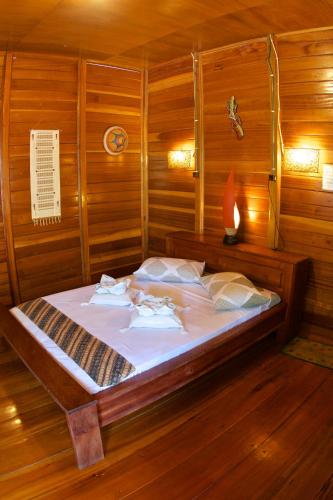 a bedroom with a bed in a wooden room at Two Fish Resort Bunaken in Bunaken