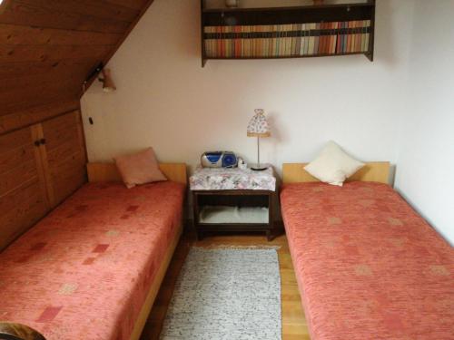 Cette chambre comprend deux lits et une table avec une lampe. dans l'établissement Belvárosi Apartman Kőszeg, à Kőszeg