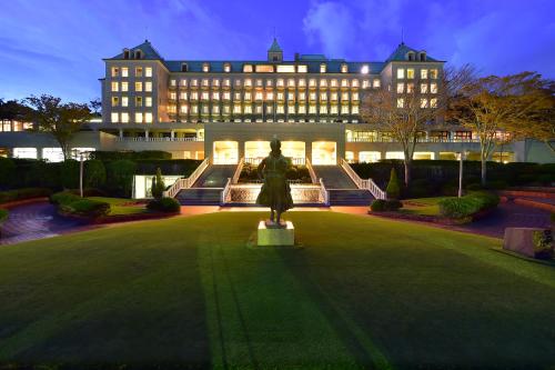 a large building with a statue in the middle of a lawn at Shizuoka Country Hamaoka Course & Hotel in Omaezaki