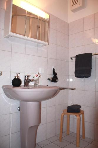 a white bathroom with a sink and a mirror at Ferienwohnung Störblick Schwerin in Raben Steinfeld