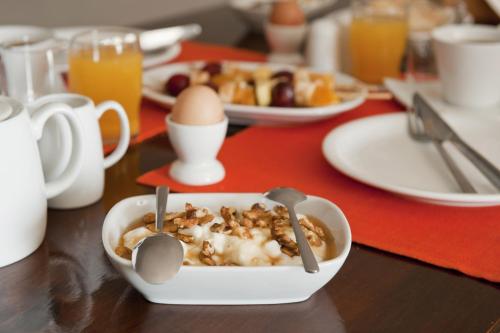 a breakfast table with a bowl of cereal and eggs at Vallais Villa in Imerovigli