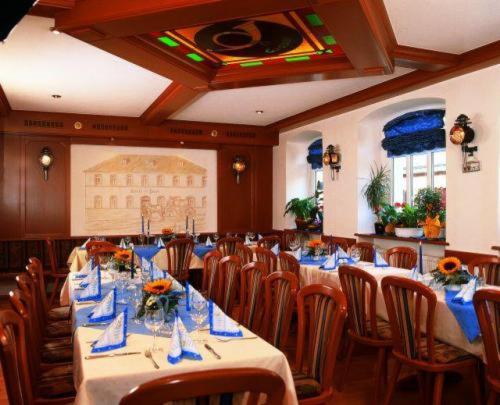 una sala da pranzo con tavoli, sedie e tovaglioli blu di Hotel Post a Nordhalben