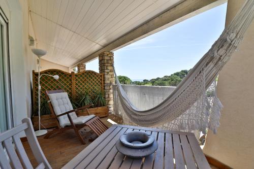 a patio with a table and a hammock on a balcony at Les Chambres d'Hôtes du Grand Mornas in Carry-le-Rouet