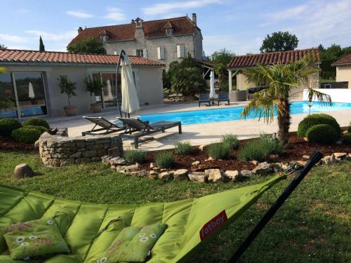 a backyard with a swimming pool and a house at Le Couvent in Saint-Jean-de Laurs