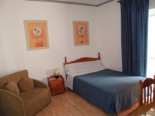 a bedroom with a bed and a couch at Hostal Fantoni in Cádiz