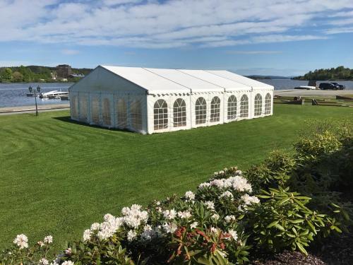 a large white building on the grass near the water at Tyrifjord Hotell in Vikersund
