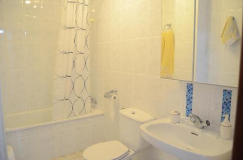Apartamento Calle Calzada في توروكس: حمام ابيض مع مرحاض ومغسلة