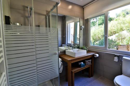 a bathroom with a sink and a glass shower at Les Chambres d'Hôtes du Grand Mornas in Carry-le-Rouet