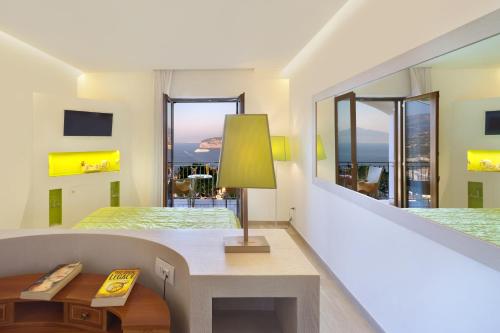 a bedroom with a bed and a desk and a mirror at Grand Hotel President in Sorrento