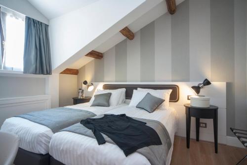 a bedroom with a bed with a black shirt on it at Hotel Grande Italia in Chioggia