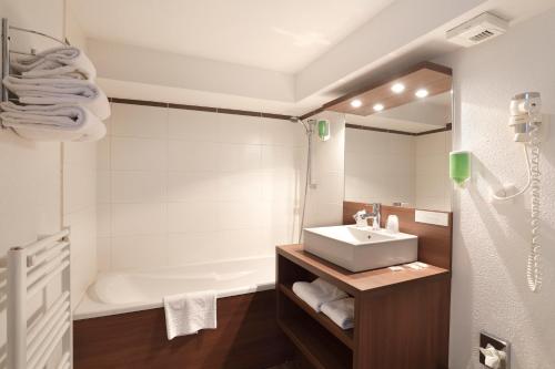 a bathroom with a sink and a bath tub at Vacancéole - Résidence Grand Massif in Morillon