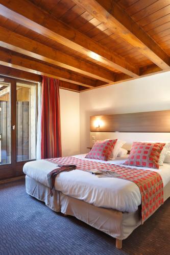 a hotel room with two beds and a window at Vacancéole - Résidence Grand Massif in Morillon