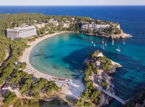 an aerial view of a beach with boats in the water at Meliá Cala Galdana in Cala Galdana