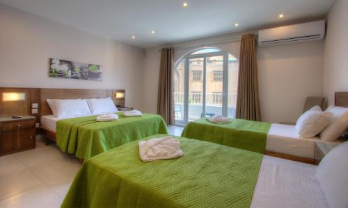 a hotel room with two beds and a window at Cerviola Hotel in Marsaskala