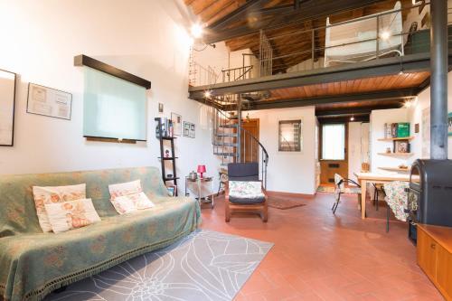 a living room with a green couch and a table at Tamerici Holiday Home by VacaVilla in San Miniato