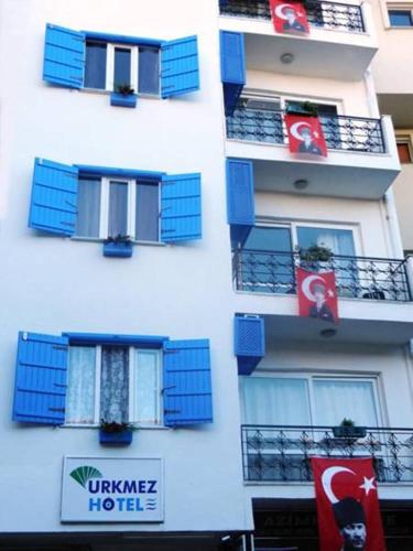 a white building with blue balconies and signs on it at Urkmez Hotel in Selcuk